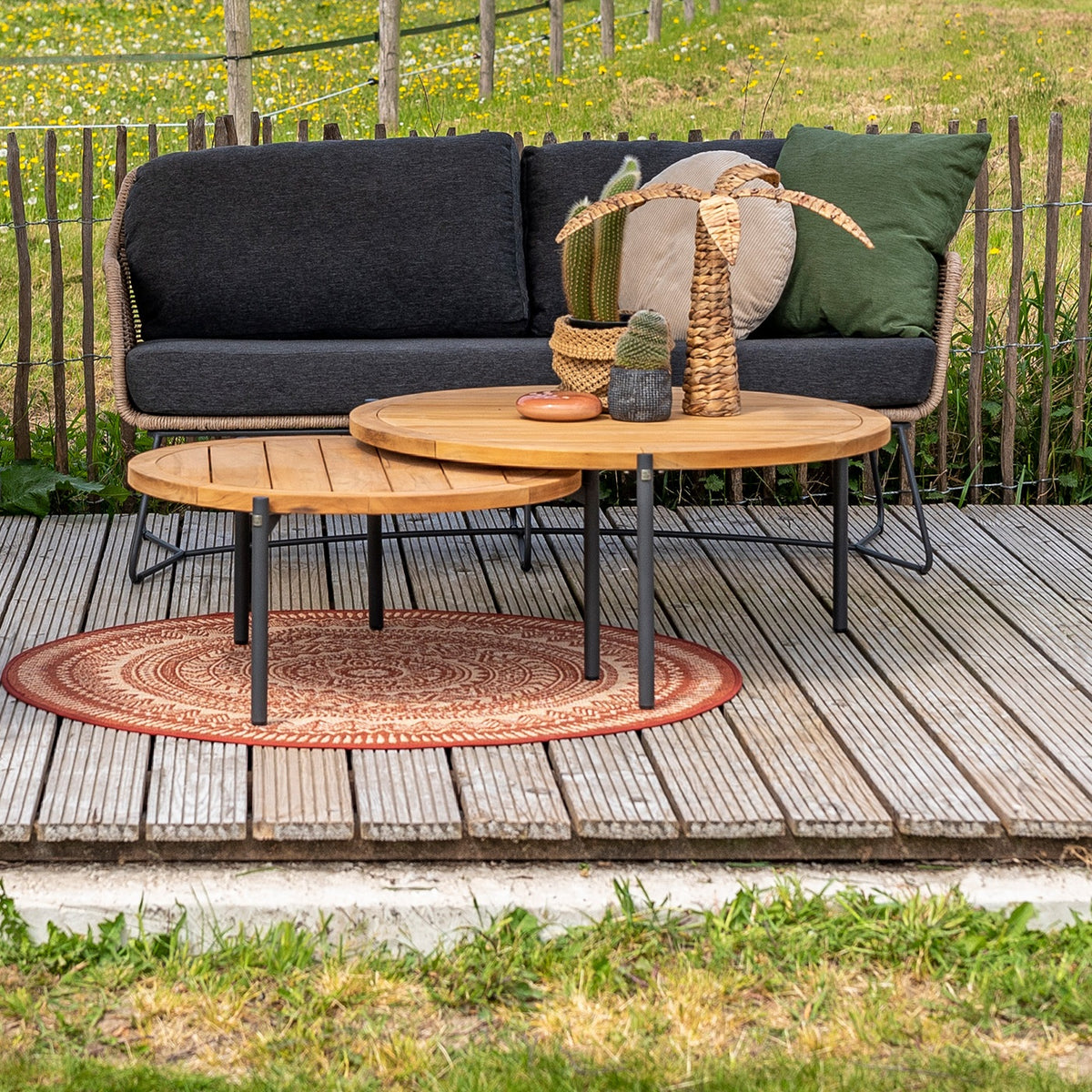 Yoga sidebord i teak med antrasitt fot foran loungesofa i hagen
